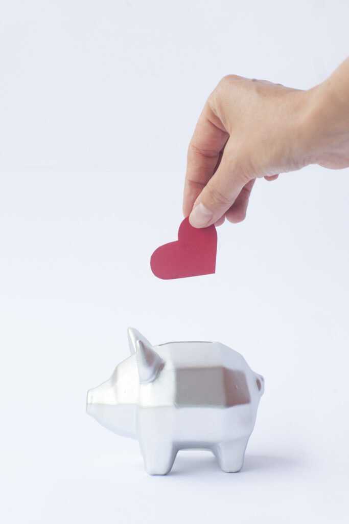 貯金箱に気持ちを入れる男性の手元
