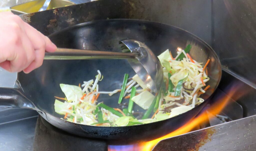 鉄フライパンで調理された香ばしい野菜炒め