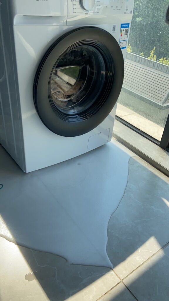 故障による水漏れで床が濡れてしまい、拭き取る様子。故障のストレスを表現。