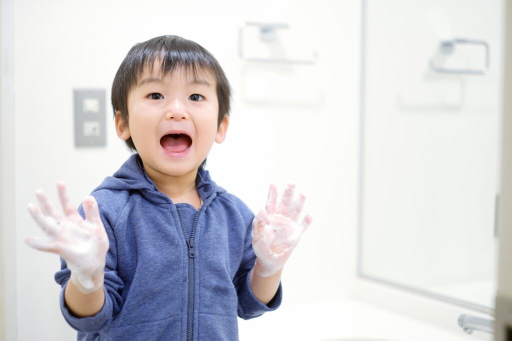 明るい洗面所で手を洗う子ども
