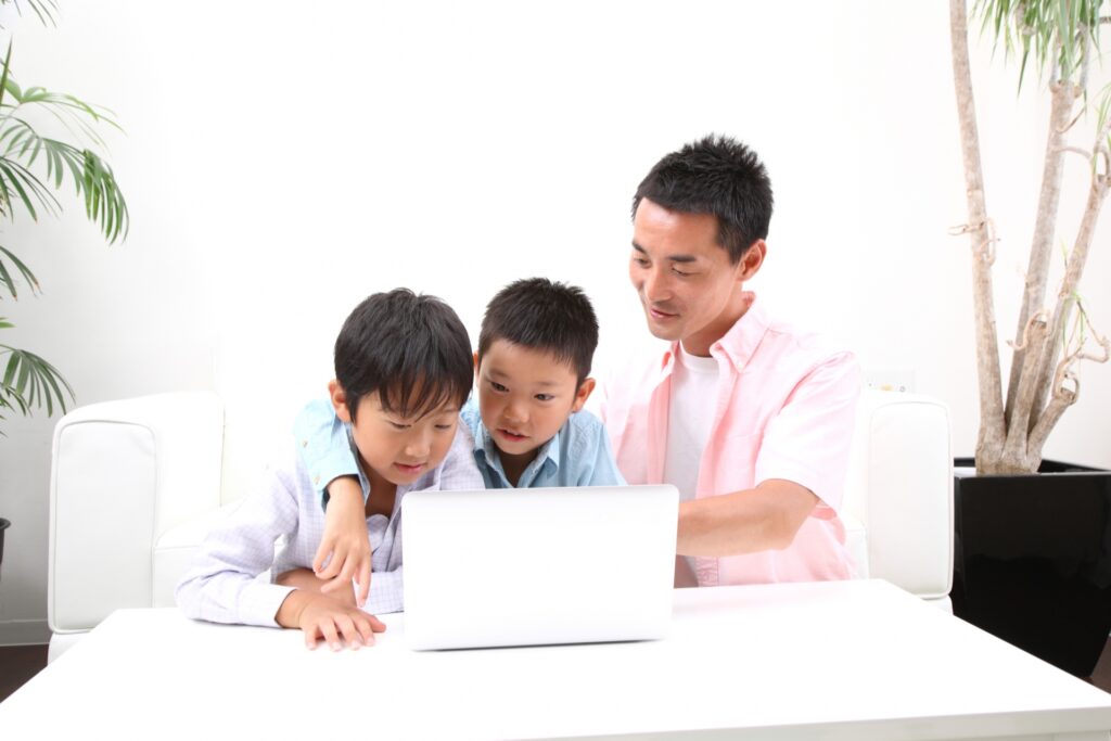 子どもにPC操作を教える親の姿